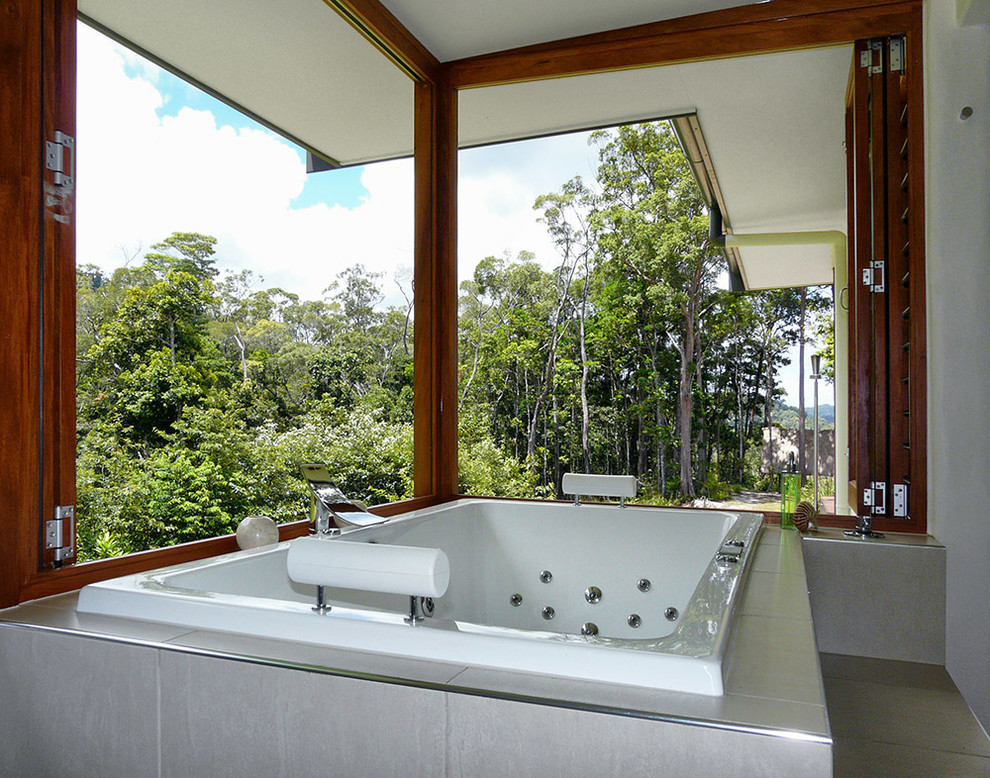 Immagine di una stanza da bagno padronale tropicale di medie dimensioni con vasca da incasso, piastrelle beige, piastrelle in gres porcellanato e pavimento in gres porcellanato