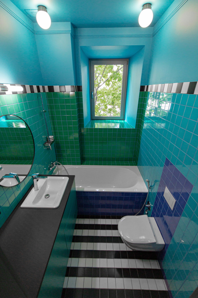 Ispirazione per una piccola stanza da bagno minimalista con WC sospeso, piastrelle multicolore, piastrelle in ceramica, lavabo integrato, top nero, un lavabo e mobile bagno incassato