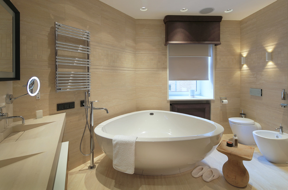 Источник вдохновения для домашнего уюта: большая главная ванная комната в современном стиле с отдельно стоящей ванной, биде, бежевыми стенами и монолитной раковиной