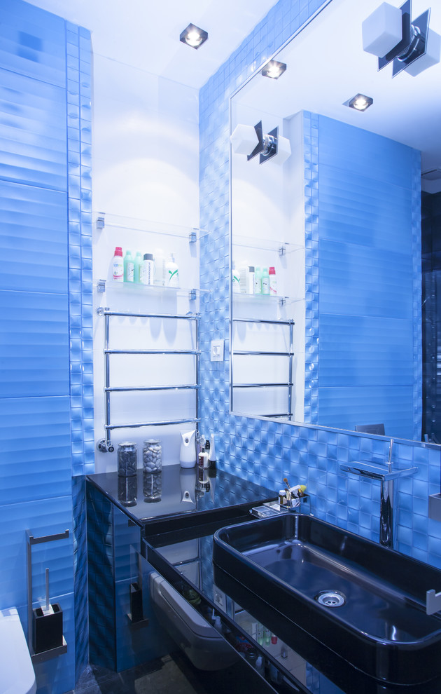 Diseño de cuarto de baño actual de tamaño medio con encimera de vidrio, baldosas y/o azulejos azules, baldosas y/o azulejos de cerámica, paredes azules y suelo de baldosas de cerámica