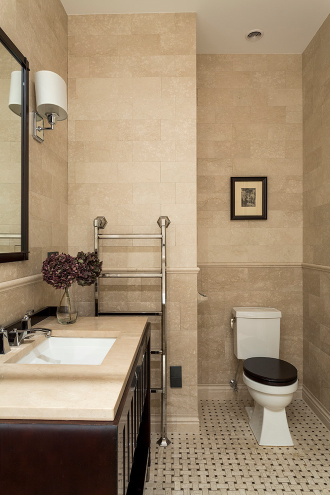Идея дизайна: главная ванная комната среднего размера в классическом стиле с плоскими фасадами, коричневыми фасадами, полновстраиваемой ванной, унитазом-моноблоком, бежевой плиткой, бежевыми стенами, мраморным полом, врезной раковиной и мраморной столешницей