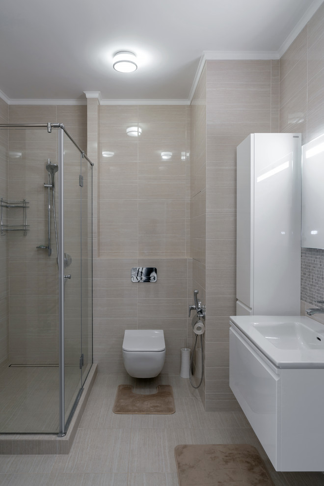 Aménagement d'une petite salle de bain moderne avec des portes de placard blanches, une douche d'angle, WC suspendus, un carrelage beige, des carreaux de céramique, un mur beige, un sol en carrelage de céramique, un lavabo suspendu, un sol beige et une cabine de douche à porte battante.