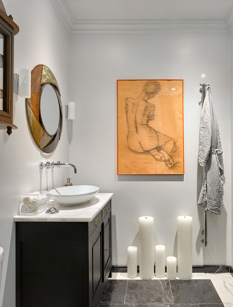 Immagine di una stanza da bagno design con ante con bugna sagomata, ante nere, pareti bianche, lavabo a bacinella e top in marmo