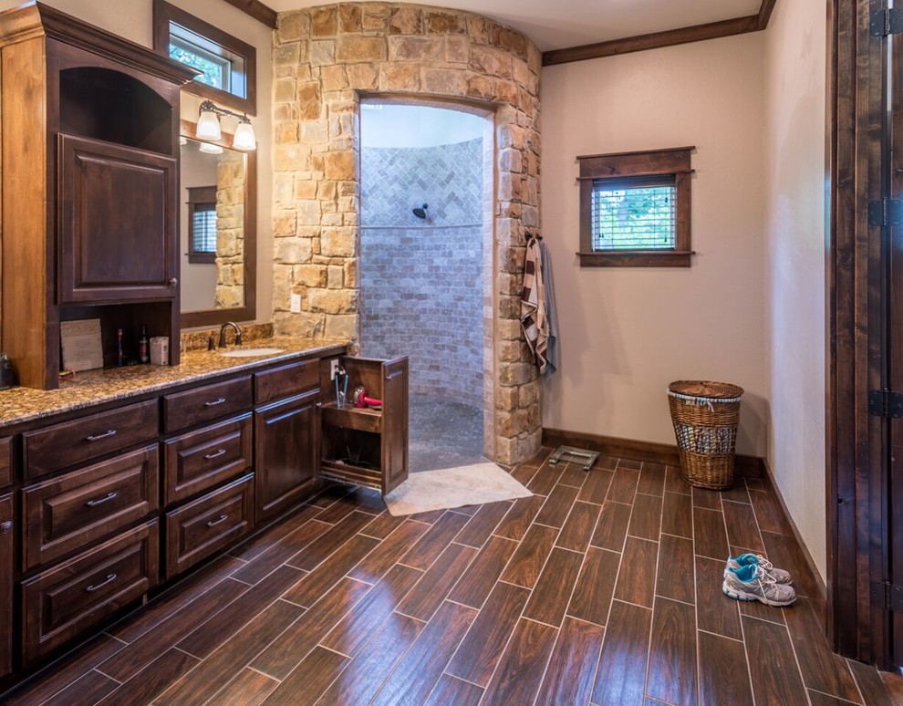 Bild på ett mellanstort vintage badrum med dusch, med luckor med upphöjd panel, skåp i mellenmörkt trä, en hörndusch, beige kakel, stenkakel, beige väggar, mörkt trägolv, ett undermonterad handfat och granitbänkskiva