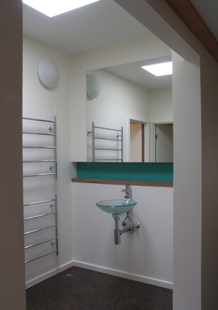 Foto de cuarto de baño principal contemporáneo de tamaño medio con baldosas y/o azulejos azules, baldosas y/o azulejos de vidrio, paredes blancas, suelo de cemento, lavabo sobreencimera y encimera de madera