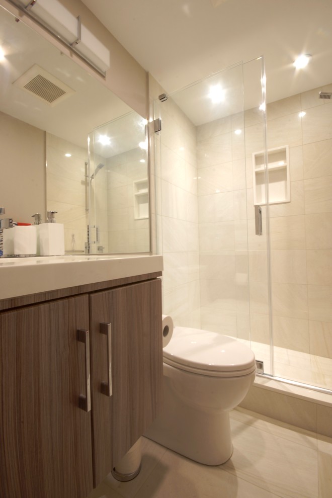 Example of a small trendy 3/4 beige tile and porcelain tile porcelain tile and beige floor bathroom design in Toronto with flat-panel cabinets, medium tone wood cabinets, a two-piece toilet, beige walls, an integrated sink and solid surface countertops