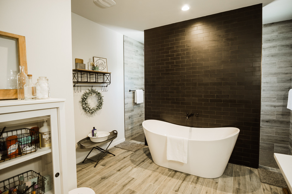 Medium sized country ensuite bathroom in Austin with freestanding cabinets, brown cabinets, a freestanding bath, a walk-in shower, a one-piece toilet, black tiles, ceramic tiles, grey walls, ceramic flooring, a pedestal sink, engineered stone worktops, white floors, an open shower and white worktops.