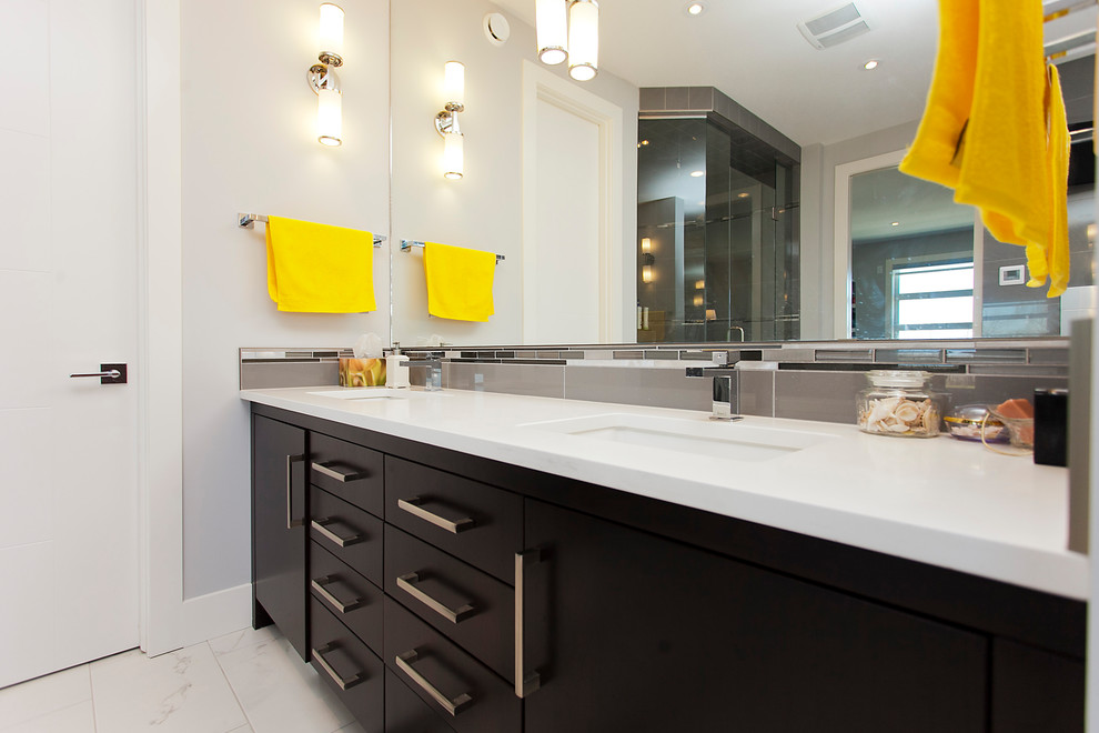 Example of a mid-sized trendy kids' gray tile and ceramic tile ceramic tile and white floor bathroom design in Calgary with flat-panel cabinets, dark wood cabinets, a two-piece toilet, gray walls, an undermount sink, quartz countertops and a hinged shower door