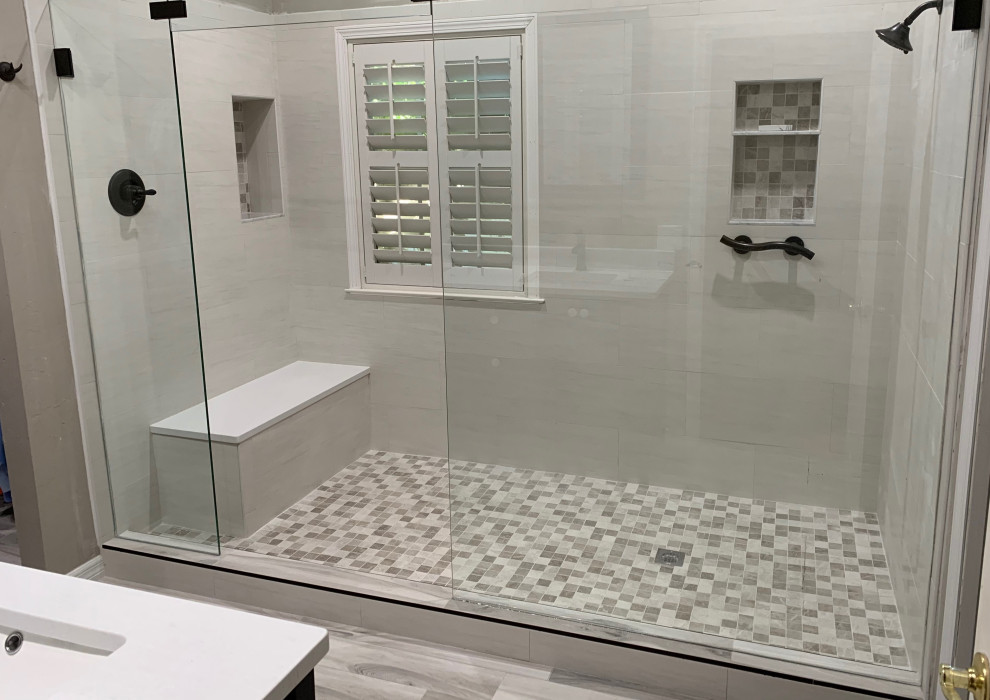 Double shower - large modern master gray tile and porcelain tile medium tone wood floor and brown floor double shower idea in Jacksonville with shaker cabinets, white cabinets and a hinged shower door