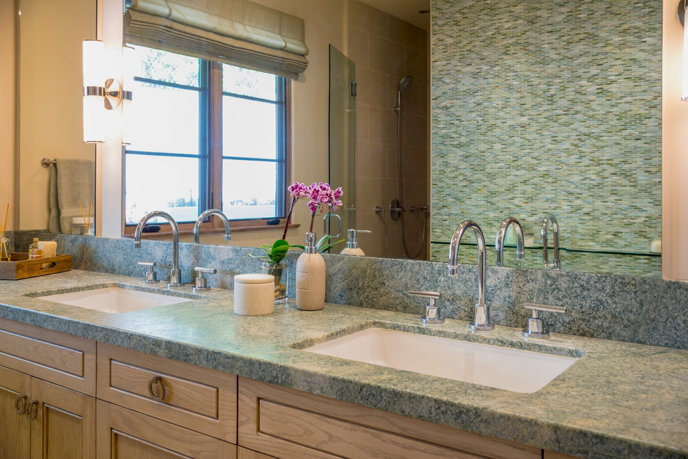 Klassisk inredning av ett mellanstort en-suite badrum, med släta luckor, blå skåp, ett fristående badkar, våtrum, flerfärgad kakel, glaskakel, beige väggar, ett undermonterad handfat, granitbänkskiva och dusch med skjutdörr