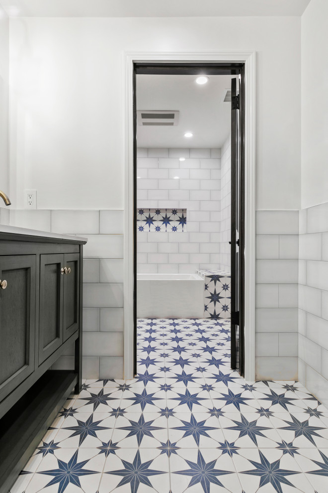 Foto på ett stort vintage badrum för barn, med skåp i shakerstil, blå skåp, ett fristående badkar, en dusch/badkar-kombination, vit kakel, porslinskakel, vita väggar, cementgolv och flerfärgat golv