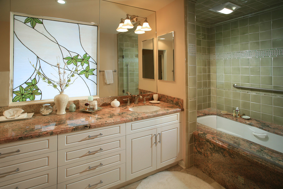 Cette photo montre une salle de bain principale chic de taille moyenne avec un lavabo encastré, un placard avec porte à panneau surélevé, des portes de placard blanches, un plan de toilette en granite, une baignoire encastrée, un combiné douche/baignoire, un carrelage vert, des carreaux de céramique, un mur rose et un sol en marbre.