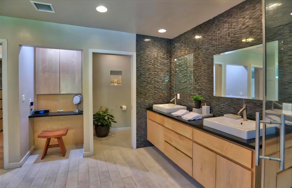 Large transitional master multicolored tile porcelain tile, gray floor and double-sink bathroom photo in Los Angeles with flat-panel cabinets, light wood cabinets, a one-piece toilet, white walls, a vessel sink, soapstone countertops, a hinged shower door, gray countertops and a floating vanity