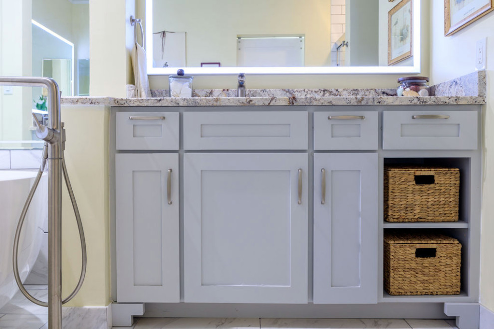 Example of a mid-sized classic master white tile and marble tile marble floor, white floor and double-sink bathroom design in Atlanta with shaker cabinets, gray cabinets, a one-piece toilet, yellow walls, an undermount sink, granite countertops, beige countertops and a freestanding vanity