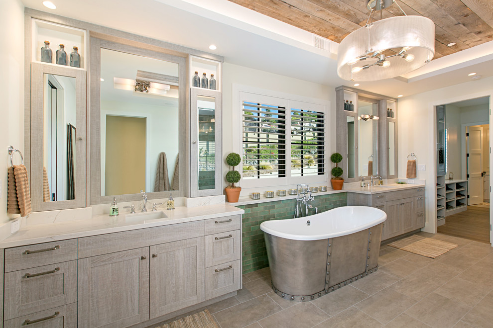 На фото: главная ванная комната в стиле кантри с фасадами в стиле шейкер, серыми фасадами, отдельно стоящей ванной, зеленой плиткой, плиткой кабанчик, белыми стенами, врезной раковиной, серым полом и белой столешницей