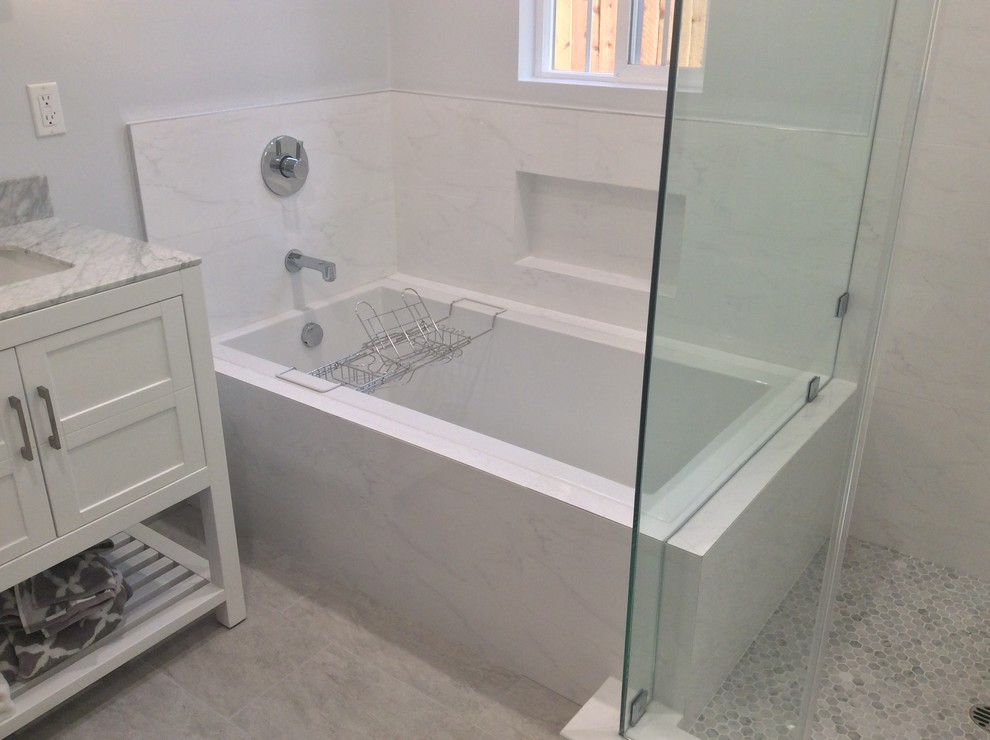 Ispirazione per una stanza da bagno minimalista di medie dimensioni con ante in stile shaker, ante bianche, vasca da incasso, doccia ad angolo, pareti bianche, pavimento con piastrelle in ceramica e top in marmo