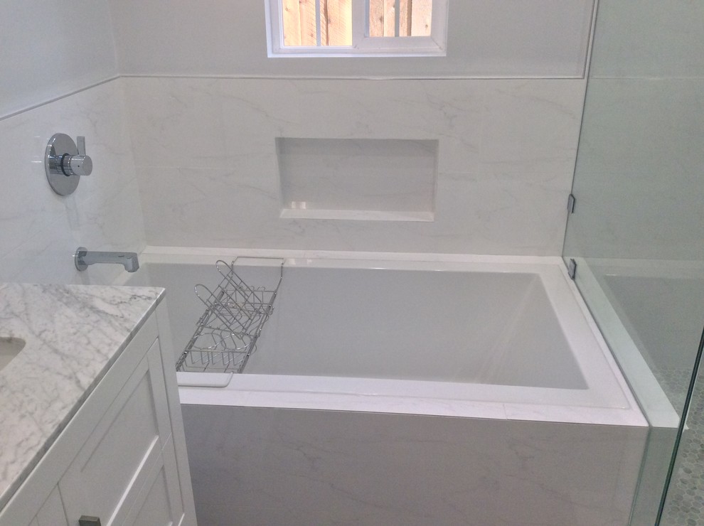 Modelo de cuarto de baño minimalista de tamaño medio con armarios estilo shaker, puertas de armario blancas, bañera encastrada, ducha esquinera, paredes blancas, suelo de baldosas de cerámica y encimera de mármol