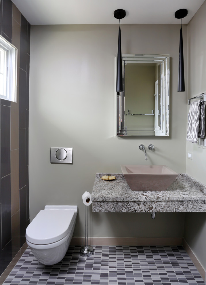 Ejemplo de cuarto de baño moderno de tamaño medio con lavabo sobreencimera, encimera de granito, sanitario de pared, baldosas y/o azulejos grises, baldosas y/o azulejos de porcelana, paredes beige, suelo de baldosas de porcelana y aseo y ducha