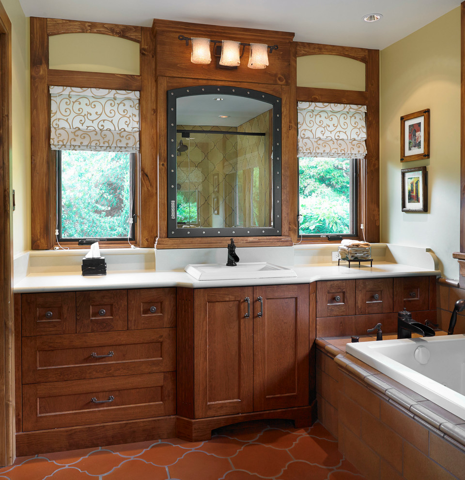 バンクーバーにあるサンタフェスタイルのおしゃれな浴室 (オーバーカウンターシンク、濃色木目調キャビネット、ドロップイン型浴槽) の写真