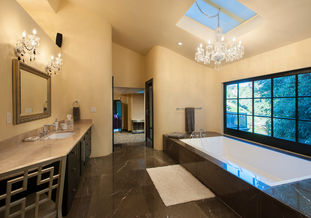 Exemple d'une salle de bain tendance en bois foncé avec un lavabo encastré, un placard à porte plane, une baignoire posée et un carrelage marron.