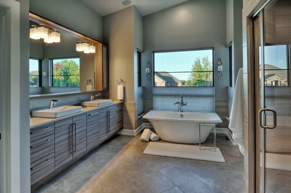 This is an example of a large midcentury ensuite bathroom in Omaha with flat-panel cabinets, grey cabinets, a freestanding bath, an alcove shower, a two-piece toilet, beige tiles, porcelain tiles, blue walls, porcelain flooring, a vessel sink, solid surface worktops, beige floors, a hinged door and beige worktops.