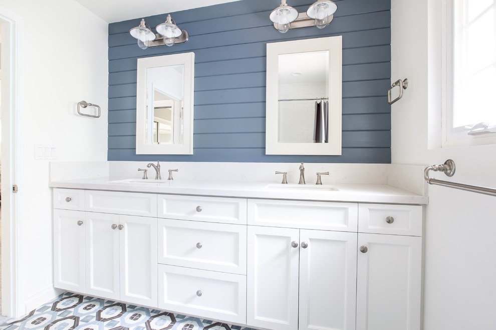 Immagine di una stanza da bagno costiera con ante in stile shaker, ante bianche, pareti blu, lavabo sottopiano, pavimento multicolore e top bianco