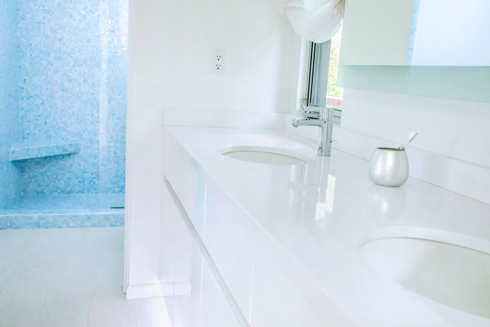 Exempel på ett mellanstort modernt badrum för barn, med släta luckor, vita skåp, en dusch i en alkov, en toalettstol med hel cisternkåpa, blå kakel, glaskakel, vita väggar, klinkergolv i keramik, ett undermonterad handfat och bänkskiva i kvartsit