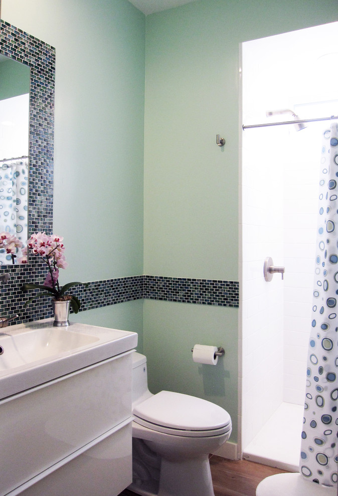 Idéer för små funkis badrum för barn, med ett väggmonterat handfat, släta luckor, vita skåp, en dusch i en alkov, en toalettstol med hel cisternkåpa, grön kakel, glaskakel, gröna väggar och klinkergolv i porslin