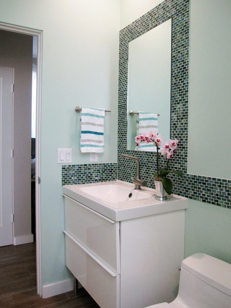 Small trendy kids' green tile and glass tile porcelain tile alcove shower photo in San Diego with a wall-mount sink, flat-panel cabinets, white cabinets, a one-piece toilet and green walls