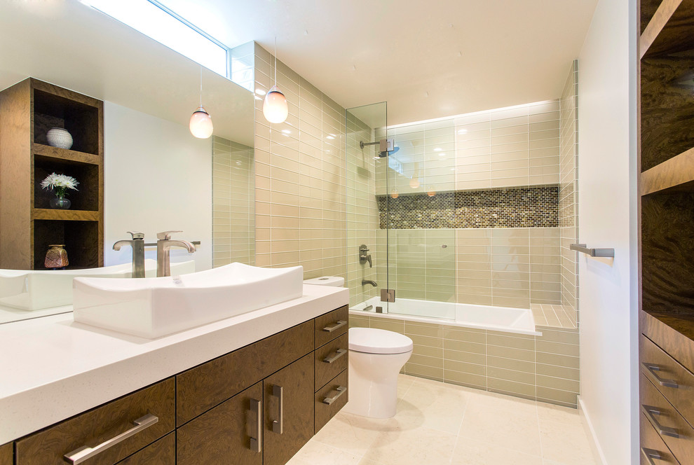 Inspiration for a medium sized contemporary bathroom in San Diego with medium wood cabinets, a submerged bath, beige tiles, glass tiles, white walls, limestone flooring, a vessel sink, engineered stone worktops, beige floors and flat-panel cabinets.