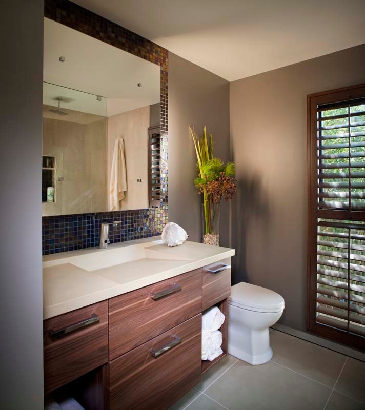 Mittelgroßes Modernes Badezimmer En Suite mit flächenbündigen Schrankfronten, hellbraunen Holzschränken, Eckdusche, Toilette mit Aufsatzspülkasten, grauen Fliesen, grauer Wandfarbe und integriertem Waschbecken in San Diego