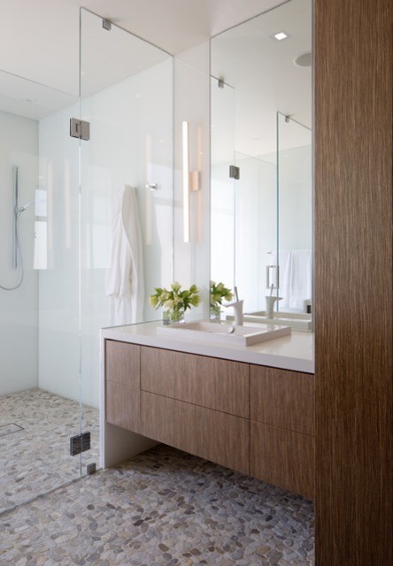 Cette photo montre une grande salle de bain principale tendance en bois brun avec un placard à porte plane, une baignoire indépendante, une plaque de galets, un sol en galet, un lavabo posé et une douche à l'italienne.