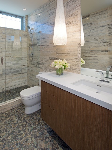Стильный дизайн: ванная комната среднего размера в современном стиле с плоскими фасадами, фасадами цвета дерева среднего тона, душем в нише, плиткой из листового камня, полом из галечной плитки, душевой кабиной и врезной раковиной - последний тренд