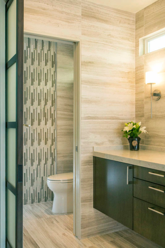 Medium sized contemporary ensuite bathroom in San Diego with flat-panel cabinets, medium wood cabinets, engineered stone worktops, beige tiles, stone tiles, limestone flooring, a submerged sink, a built-in shower, a one-piece toilet, beige walls, beige floors and an open shower.