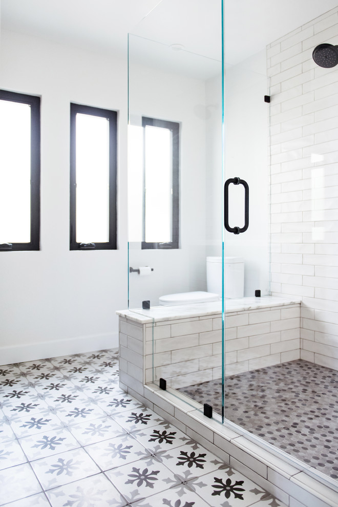 Inspiration för ett mellanstort 60 tals vit vitt en-suite badrum, med luckor med profilerade fronter, svarta skåp, en dusch i en alkov, vit kakel, tunnelbanekakel, vita väggar, cementgolv, ett undermonterad handfat, marmorbänkskiva, flerfärgat golv och dusch med gångjärnsdörr
