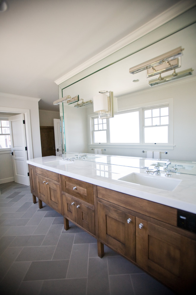 Foto di una stanza da bagno tradizionale con lavabo sottopiano, ante in stile shaker, ante in legno bruno e piastrelle in pietra