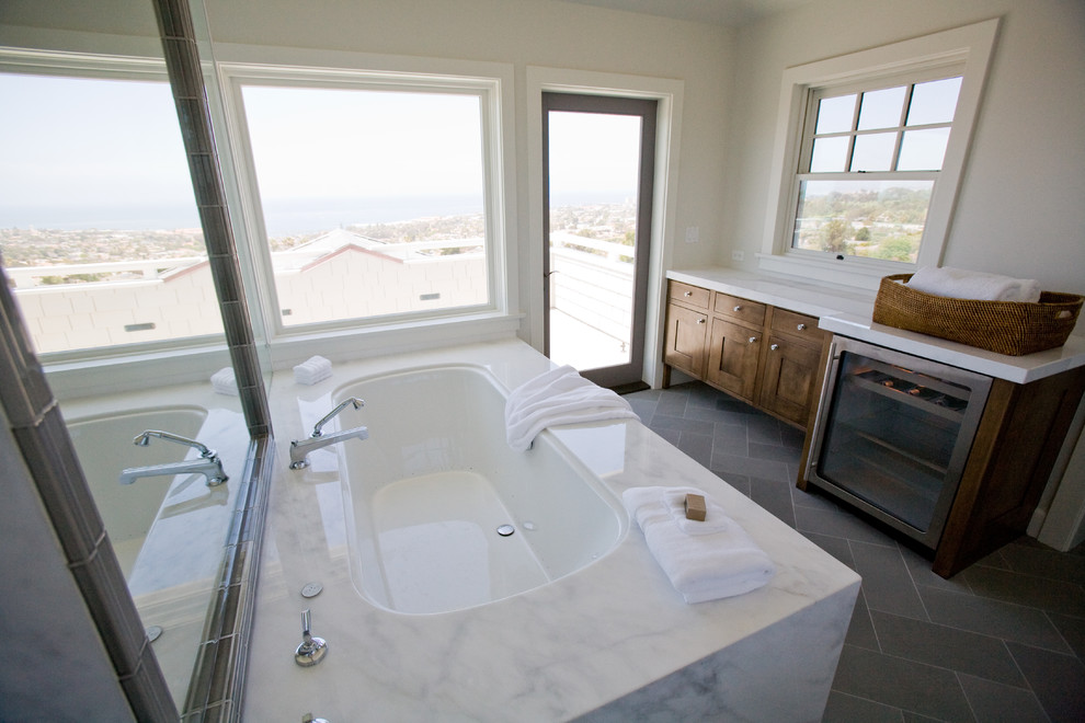 Immagine di una stanza da bagno chic con ante in stile shaker, ante in legno bruno e vasca sottopiano