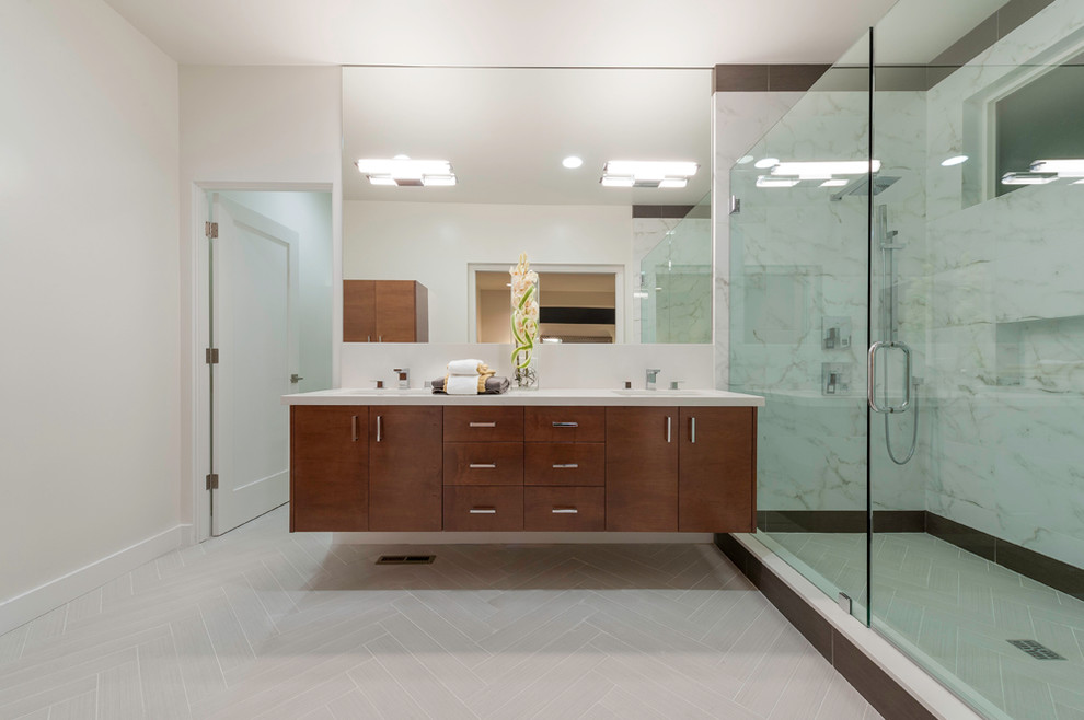 Modern inredning av ett badrum, med ett undermonterad handfat, släta luckor, skåp i mörkt trä, bänkskiva i kvarts, en öppen dusch, porslinskakel och klinkergolv i porslin