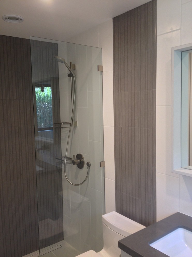 Foto di una stanza da bagno padronale moderna di medie dimensioni con doccia alcova, WC monopezzo, piastrelle grigie, piastrelle bianche, piastrelle in ceramica, pareti bianche, lavabo sottopiano, top in superficie solida e top grigio