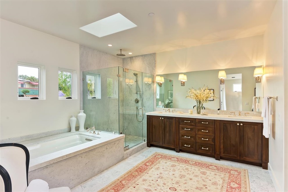 Immagine di una grande stanza da bagno padronale mediterranea con ante in stile shaker, ante in legno bruno, top in marmo, vasca da incasso, piastrelle grigie, pareti bianche e pavimento con piastrelle in ceramica