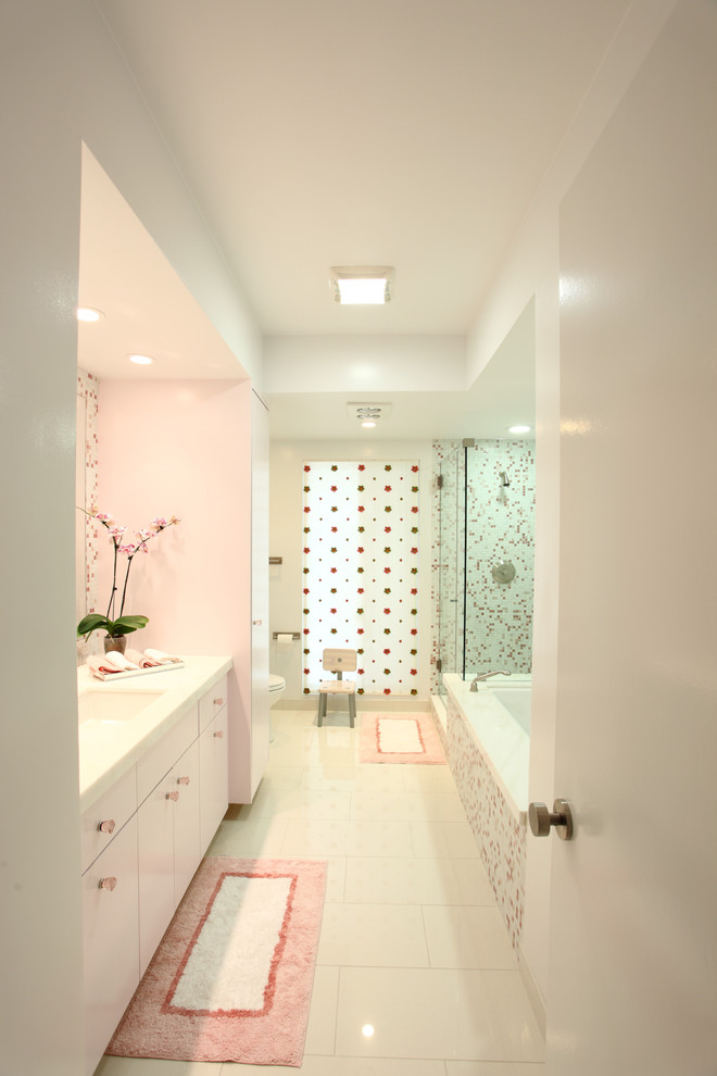 На фото: детская ванная комната среднего размера в стиле модернизм с белыми фасадами, ванной в нише, белыми стенами, плоскими фасадами, душем в нише, раздельным унитазом, белой плиткой, стеклянной плиткой, полом из керамогранита, врезной раковиной и мраморной столешницей