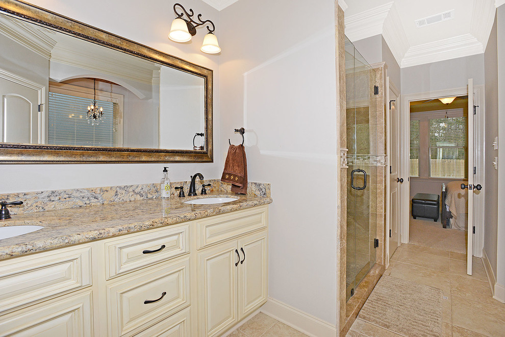 Mid-sized elegant master bathroom photo in New Orleans with light wood cabinets and granite countertops