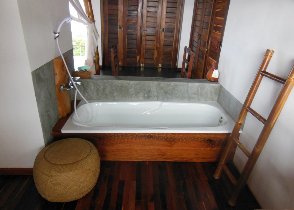 На фото: главная ванная комната среднего размера в морском стиле с открытыми фасадами, фасадами цвета дерева среднего тона, столешницей из дерева, накладной ванной, душем над ванной, серыми стенами и темным паркетным полом