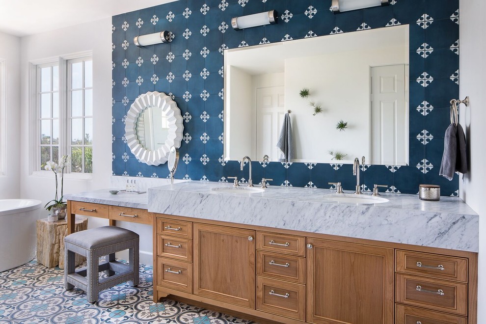 Beach style blue tile and cement tile blue floor freestanding bathtub photo in Santa Barbara with an undermount sink, marble countertops, gray countertops, recessed-panel cabinets, medium tone wood cabinets and white walls