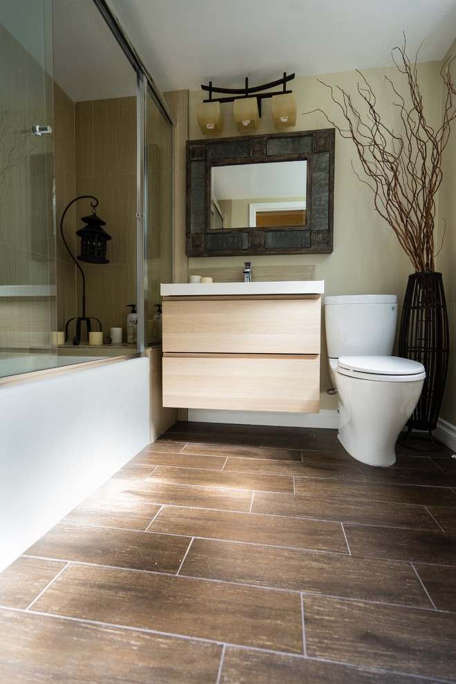Medium sized world-inspired ensuite bathroom in San Diego with flat-panel cabinets, light wood cabinets, a built-in bath, an alcove shower, a two-piece toilet, beige tiles, porcelain tiles, beige walls, medium hardwood flooring, a built-in sink, quartz worktops, white worktops, a single sink and a floating vanity unit.