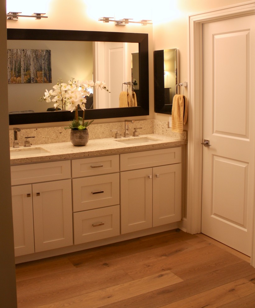 Imagen de cuarto de baño principal contemporáneo pequeño con armarios estilo shaker, puertas de armario blancas, paredes grises, suelo de madera clara, lavabo bajoencimera y encimera de cuarzo compacto