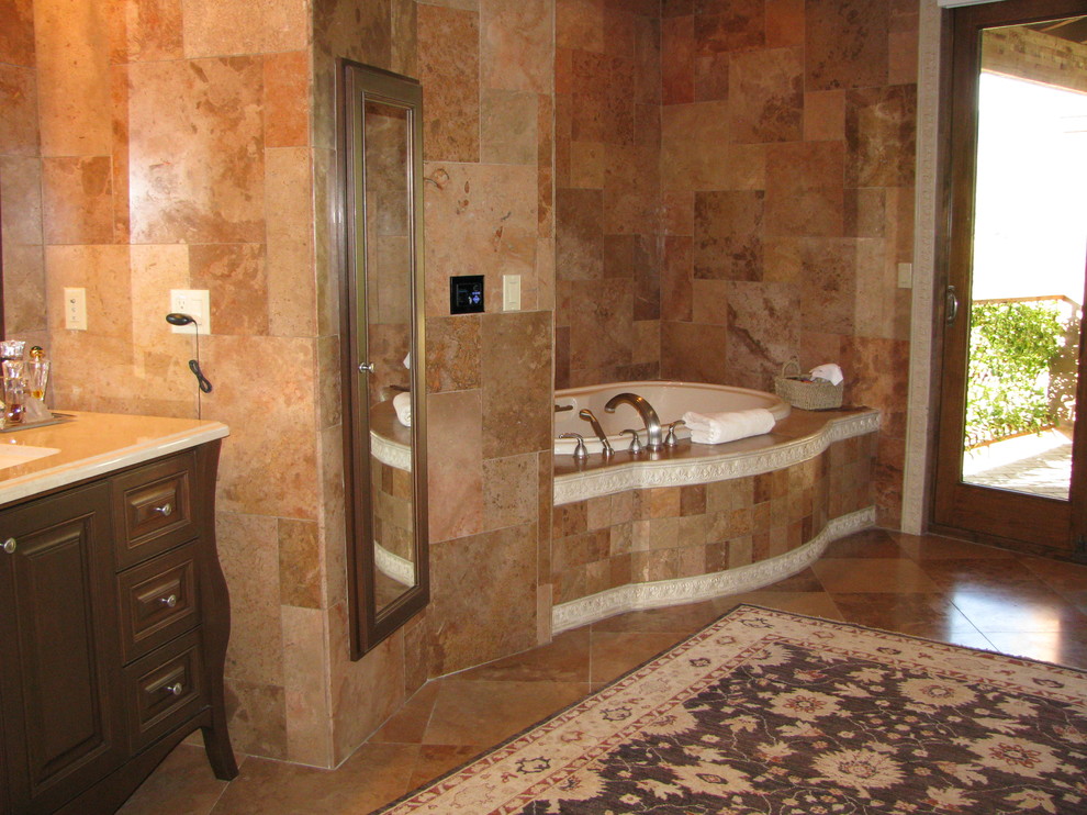 Пример оригинального дизайна: большая главная ванная комната в средиземноморском стиле с фасадами островного типа, темными деревянными фасадами, накладной ванной, открытым душем, коричневой плиткой, керамогранитной плиткой, полом из керамогранита, врезной раковиной, столешницей из искусственного камня, коричневым полом, душем с распашными дверями и бежевой столешницей