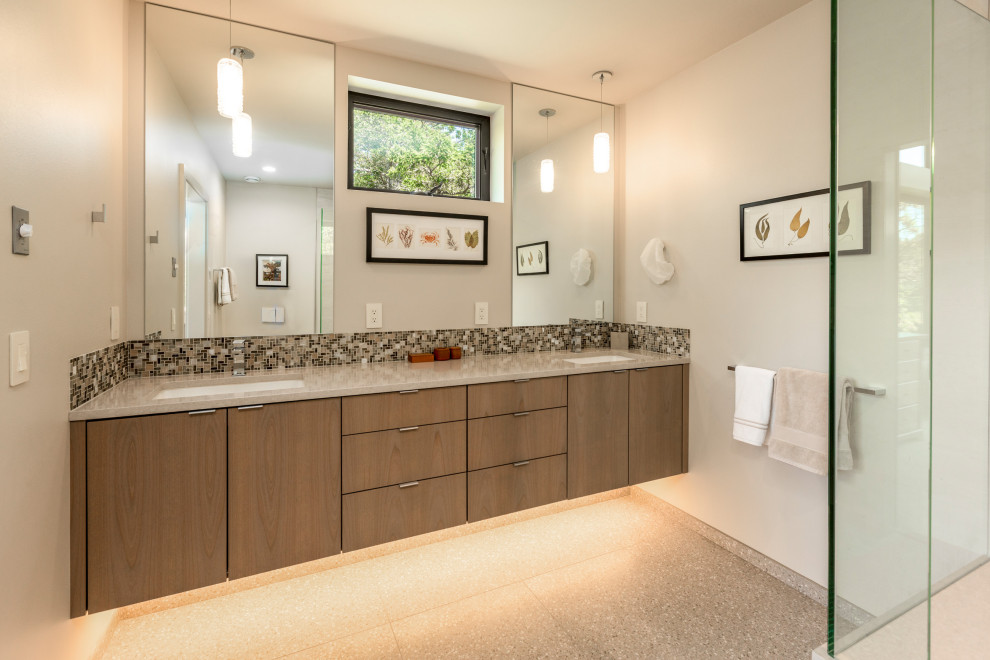 Mid-sized 1950s master multicolored tile and glass tile limestone floor, multicolored floor and double-sink bathroom photo in Seattle with flat-panel cabinets, medium tone wood cabinets, a wall-mount toilet, white walls, an undermount sink, quartz countertops, white countertops and a floating vanity