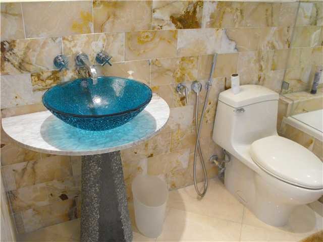 Ispirazione per una piccola stanza da bagno moderna con lavabo a bacinella, doccia ad angolo, WC monopezzo, top in vetro e piastrelle multicolore