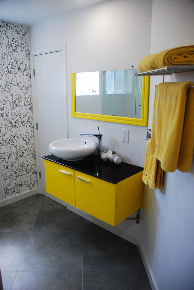 Mittelgroßes Modernes Badezimmer mit Aufsatzwaschbecken, flächenbündigen Schrankfronten, gelben Schränken, Granit-Waschbecken/Waschtisch, Einbaubadewanne, Duschbadewanne, Wandtoilette, grauen Fliesen, Porzellanfliesen, weißer Wandfarbe und Porzellan-Bodenfliesen in San Francisco